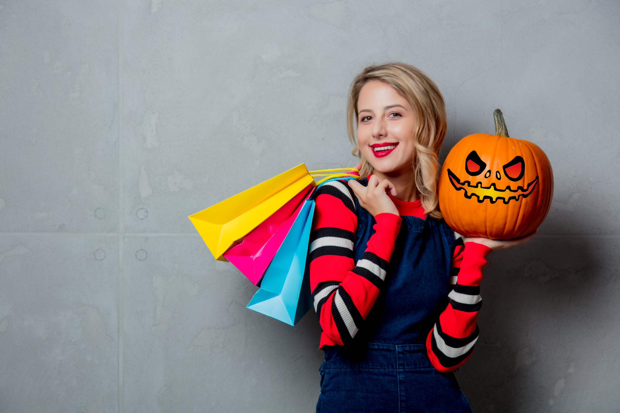 girl with shopping bags and halloween pumpkin