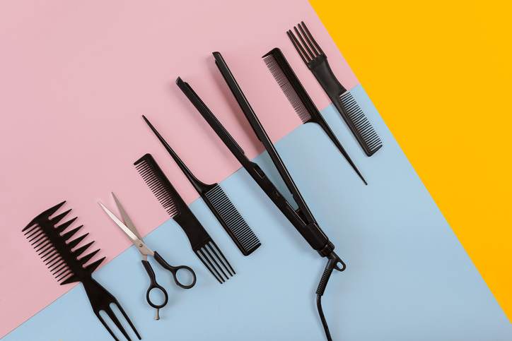Various hair styling devices on the color blue, yellow, pink paper background, top view Various hair styling devices on the color blue, yellow, pink paper background, top view
